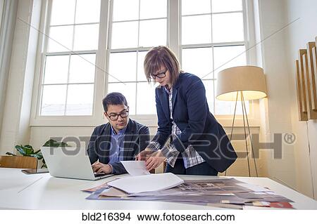 Business people working at desk in office View Large Photo Image Picture - Business people working at desk in office. Fotosearch