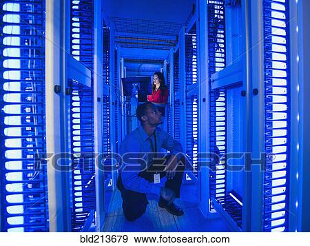 Stock Photo - Business people working in server room. Fotosearch