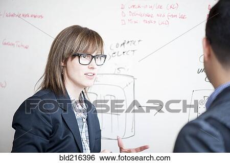 Business people writing on whiteboard in office View Large Photo Image Stock Photograph - Business people writing on whiteboard in office. Fotosearch