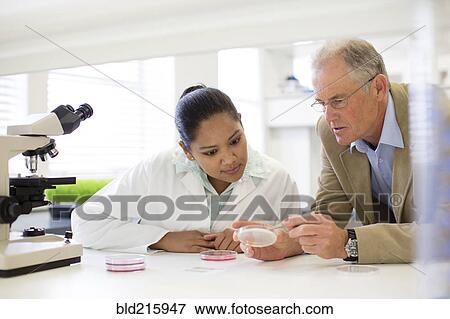 Stock Photo - Businessman and scientist examining sample in laboratory. Fotosearch