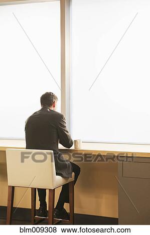 Stock Photo - Businessman drinking coffee in cafe. Fotosearch