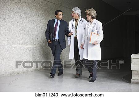 Businessman talking to doctors View Large Photo Image Stock Image - Businessman talking to doctors. Fotosearch