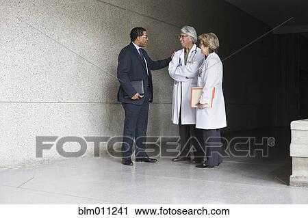 Businessman talking to doctors View Large Photo Image Stock Image - Businessman talking to doctors. Fotosearch