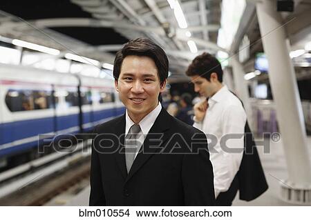Businessmen waiting on platform for subway train View Large Photo Image Picture - Businessmen waiting on platform for subway train. Fotosearch