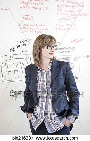 Businesswoman standing at whiteboard in office View Large Photo Image Stock Photo - Businesswoman standing at whiteboard in office. Fotosearch