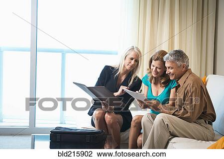 Businesswoman talking to couple on sofa View Large Photo Image Stock Image - Businesswoman talking to couple on sofa. Fotosearch