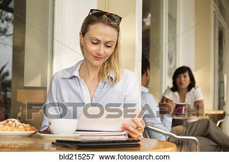 Stock Photo - Businesswoman using digital tablet in cafe. Fotosearch