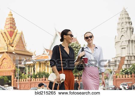 Businesswomen walking by ornate temple, Phnom Penh, Cambodia View Large Photo Image Stock Photography - Businesswomen walking by ornate temple, Phnom Penh, Cambodia. Fotosearch