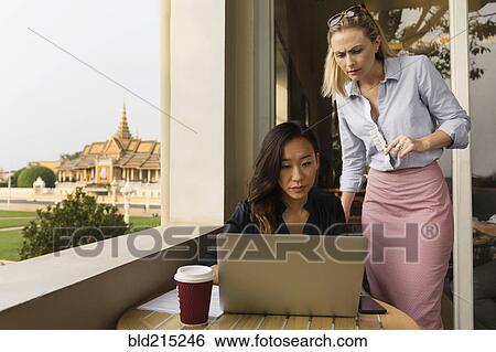 Businesswomen working on laptop in cafe, Phnom Penh, Cambodia View Large Photo Image Stock Photograph - Businesswomen working on laptop in cafe, Phnom Penh, Cambodia. Fotosearch
