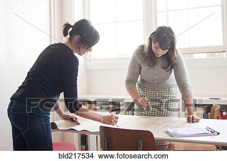 Picture - Businesswomen working together in office. Fotosearch