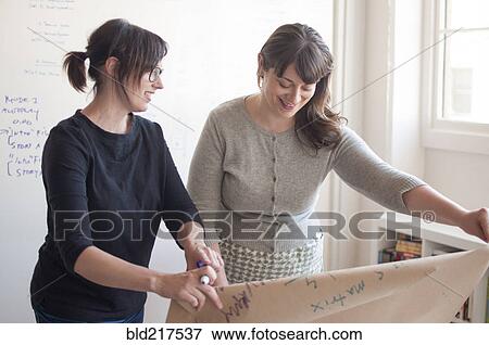 Businesswomen working together in office View Large Photo Image Stock Photo - Businesswomen working together in office. Fotosearch