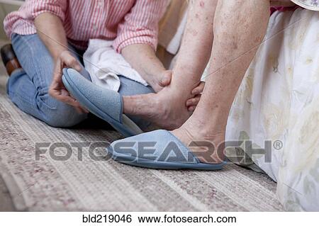 Stock Photograph - Caregiver helping older woman in home. Fotosearch