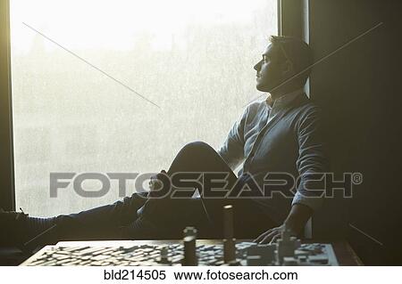 Stock Photography - Caucasian architect at office window with urban model. Fotosearch