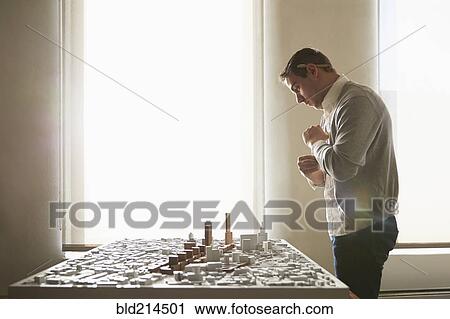 Caucasian architect examining urban model in office View Large Photo Image Stock Image - Caucasian architect examining urban model in office. Fotosearch