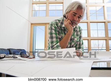 Caucasian architect looking at blueprints View Large Photo Image Stock Image - Caucasian architect looking at blueprints. Fotosearch