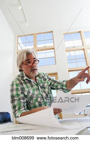 Caucasian architect working in office View Large Photo Image Stock Photo - Caucasian architect working in office. Fotosearch