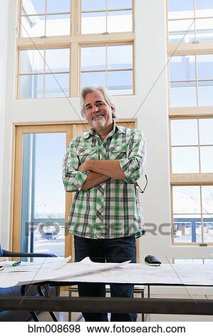 Stock Photo - Caucasian architect working with blueprints. Fotosearch