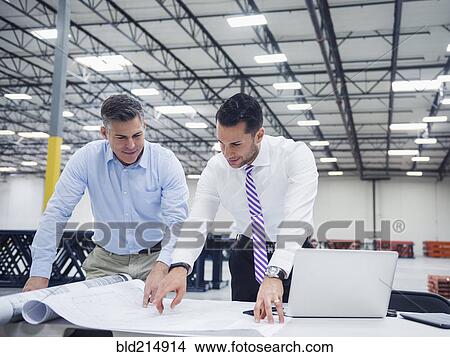 Picture - Caucasian architects working in warehouse. Fotosearch