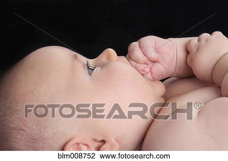 Stock Image - Caucasian baby biting hand. Fotosearch