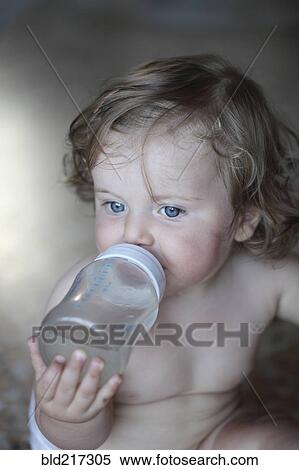 Stock Photography - Caucasian baby girl drinking bottle. Fotosearch