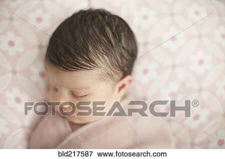 Stock Photo - Caucasian baby girl swaddled in blanket. Fotosearch