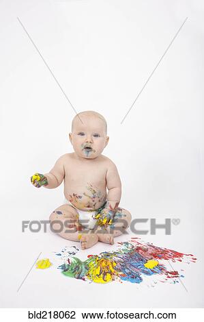 Stock Image - Caucasian baby playing with paint. Fotosearch