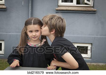Caucasian boy kissing sister in backyard View Large Photo Image Stock Photo - Caucasian boy kissing sister in backyard. Fotosearch