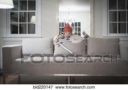 Caucasian boy playing with toy sword in living room View Large Photo Image Stock Photo - Caucasian boy playing with toy sword in living room. Fotosearch