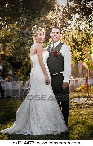Caucasian bride and groom smiling at outdoor reception View Large Photo Image Stock Image - Caucasian bride and groom smiling at outdoor reception. Fotosearch
