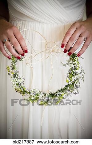 Stock Photo - Caucasian bride holding flower headband. Fotosearch