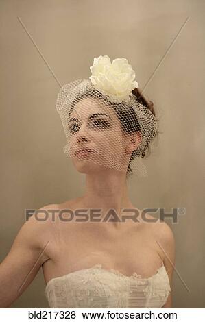 Stock Photo - Caucasian bride wearing flower and birdcage veil. Fotosearch