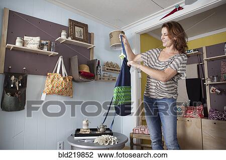 Stock Image - Caucasian business owner arranging items in store. Fotosearch