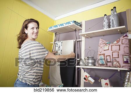 Caucasian business owner arranging items in store View Large Photo Image Stock Photograph - Caucasian business owner arranging items in store. Fotosearch