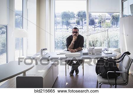Stock Photography - Caucasian businessman sitting in modern office. Fotosearch