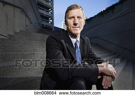 Picture - Caucasian businessman sitting on outdoor staircase. Fotosearch