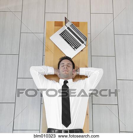 Stock Image - Caucasian businessman sleeping on bench. Fotosearch