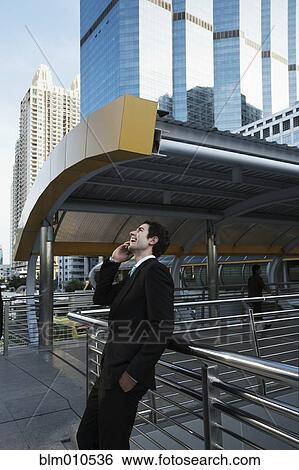 Caucasian businessman talking on cell phone outdoors View Large Photo Image Stock Photograph - Caucasian businessman talking on cell phone outdoors. Fotosearch