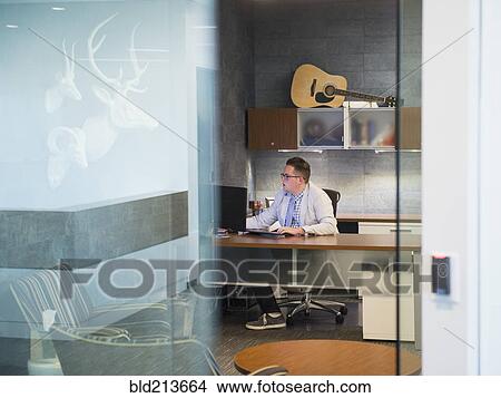 Caucasian businessman working at desk in office View Large Photo Image Picture - Caucasian businessman working at desk in office. Fotosearch