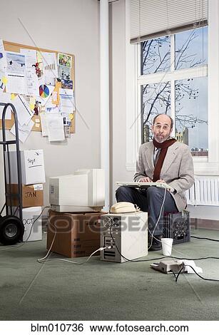 Stock Photograph - Caucasian businessman working in empty office. Fotosearch