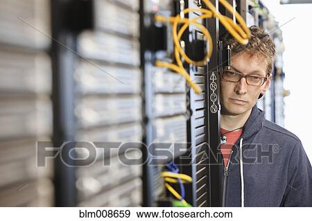 Stock Photo - Caucasian businessman working in office technology room. Fotosearch