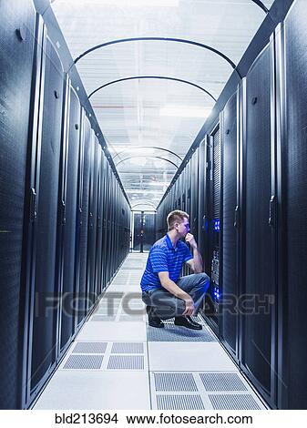 Caucasian businessman working in server room View Large Photo Image Picture - Caucasian businessman working in server room. Fotosearch