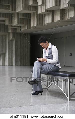 Caucasian businesswoman text messaging in lobby View Large Photo Image Stock Image - Caucasian businesswoman text messaging in lobby. Fotosearch