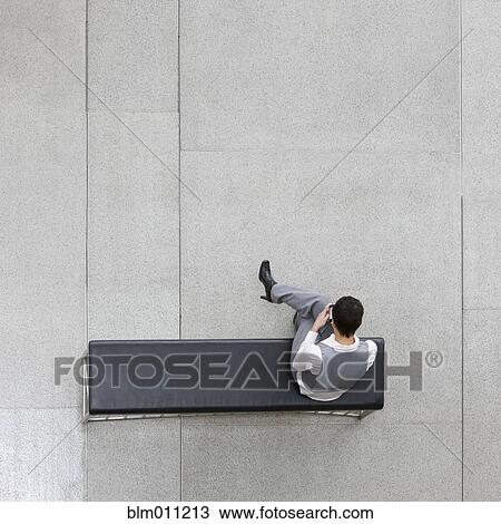 Stock Image - Caucasian businesswoman using cell phone in lobby. Fotosearch