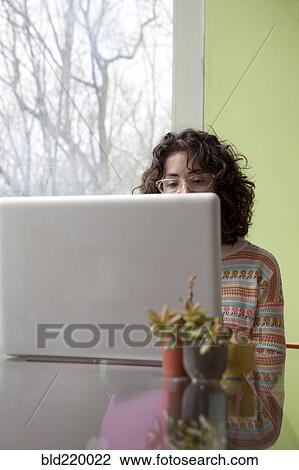 Stock Image - Caucasian businesswoman using laptop at desk. Fotosearch