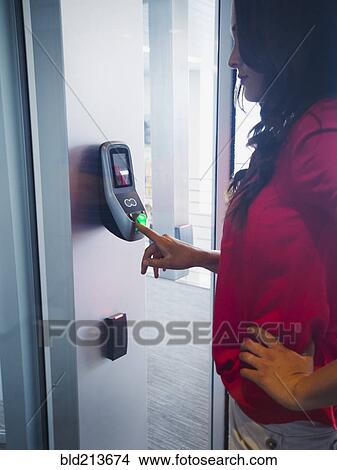 Picture - Caucasian businesswoman using fingerprint lock system in office. Fotosearch