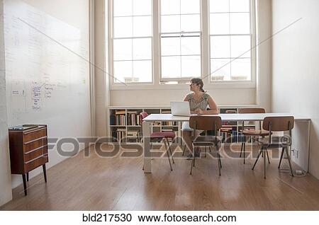 Stock Image - Caucasian businesswoman working on laptop in office. Fotosearch