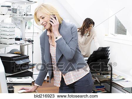 Caucasian businesswomen talking on cell phone in office View Large Photo Image Stock Image - Caucasian businesswomen talking on cell phone in office. Fotosearch