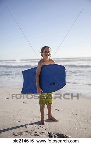 Caucasian by carrying boogie board on beach View Large Photo Image Stock Photograph - Caucasian by carrying boogie board on beach. Fotosearch