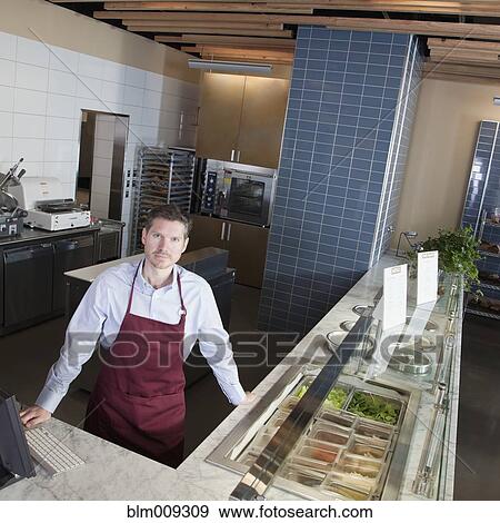 Stock Photo - Caucasian cafe owner standing in cafe. Fotosearch
