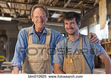Stock Photography - Caucasian carpenters standing together in workshop. Fotosearch